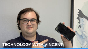 Technology with Vincent: Man wearing glasses and a black shirt holding a cell phone pointing at it.
